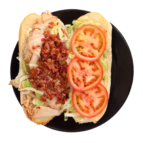 A sandwich with meat, tomatoes and lettuce on it.